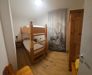 una camera da letto con un letto a castello con un cervo sul muro di Appartamenti Sole a Vermiglio