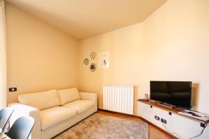 un soggiorno con divano e TV a schermo piatto di Italian Vacation Homes Unit2B Iseo Lake a Tavernola Bergamasca