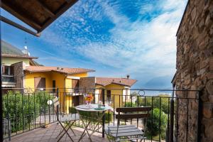 un patio con tavolo e sedie su un balcone di Italian Vacation Homes Unit2B Iseo Lake a Tavernola Bergamasca