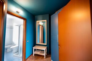 un bagno con pareti blu e arancioni e un water di Italian Vacation Homes Unit2B Iseo Lake a Tavernola Bergamasca Altre 19 foto