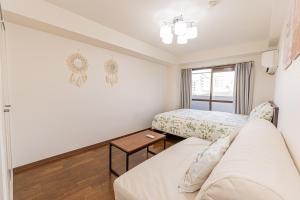 Zimmer mit Sofa, Bett und Fenster in der Unterkunft sakura 405 in Tokio