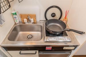 eine Bratpfanne auf einem Herd in einer Küche in der Unterkunft sakura 405 in Tokio + 6 Fotos