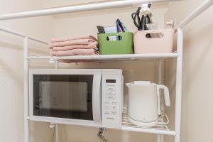 eine Mikrowelle auf einem Regal in einer Küche in der Unterkunft sakura 405 in Tokio