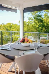 een eettafel met een schaal fruit en wijnglazen bij Villas Vista Del Mar in Sainte-Anne