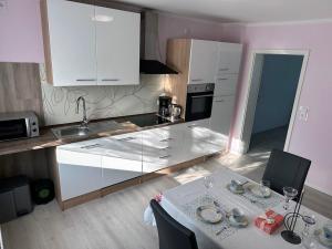 a kitchen with white cabinets and a table with plates on it at Ferienwohnung Lena in Morbach