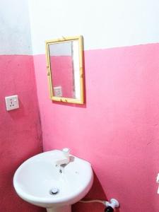 a bathroom with a white sink and a mirror at Fr Resort in Arugam Bay