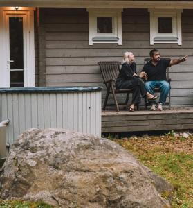 een man en vrouw die op de veranda van een huis zitten bij Merineitsi peamaja saunaga kahele in Tahkuna +13 foto's