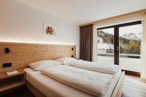 a bedroom with a bed and a large window at Apartments Roda de Ciar in Badia