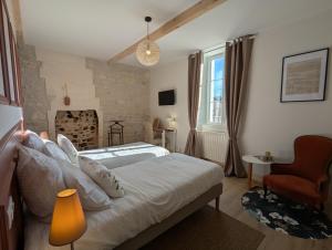 a bedroom with a bed and a chair in it at Le Brissonneau - Séjour Truffe in Saint-Saturnin +42 photos