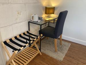 a desk with a chair and a table with a microwave at Le BRISSONNEAU in Saint-Saturnin