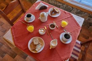 een tafel met borden eten en kopjes koffie bij Melewe Moquehue in Moquehue