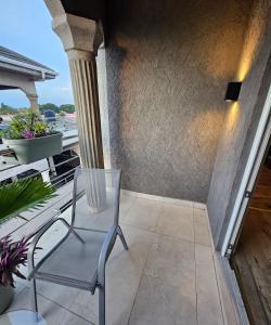 a chair sitting on the balcony of a house at Appartement blue sky unique et élégante in Lomé