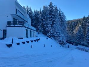 ein Gebäude im Schnee mit schneebedeckten Bäumen in der Unterkunft Osicki Sport Resort in Korbielów