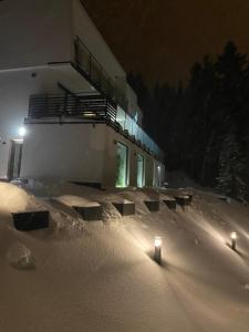 Ein Gebäude mit zwei Kerzen im Schnee bei Nacht in der Unterkunft Osicki Sport Resort in Korbielów