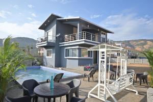 eine Villa mit Swimmingpool und ein Haus in der Unterkunft EMPYREAN STAY II LEONCINO VILLA II 4BHK II AC II LARGE POOL lI WIFI II BBQ in Lonavla