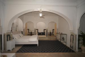 a bedroom with a bed and a ceiling fan at Bagru Haveli in Jaipur