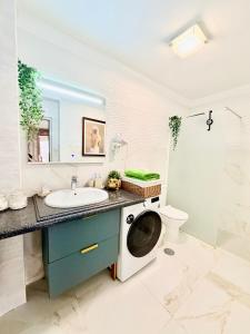 ein Badezimmer mit Waschbecken und Waschmaschine in der Unterkunft Apartment with terrace and pool, Los Cristianos in Los Cristianos