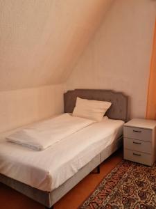 een kleine slaapkamer met een bed en een nachtkastje bij Pension Pale' Bach in Bad Hersfeld +49 foto's