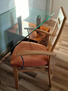 een glazen tafel en een houten stoel met een glazen tafel en een glazen stoel bij Pension Pale' Bach in Bad Hersfeld