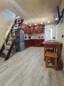 een grote keuken met een houten vloer en een trap bij Стрийський Двір in Tsjernivsi