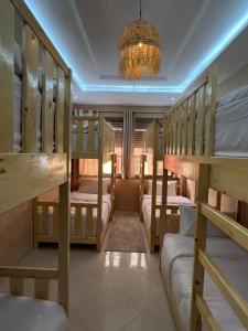een kamer met 4 stapelbedden en een kroonluchter bij Shams House imsouane in Imsouane