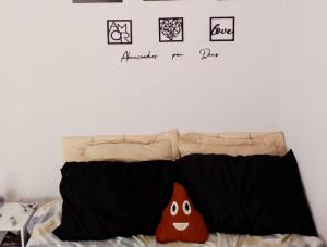 a bed with two pillows on top of it at Kit Net Cidade Universitária in Limeira