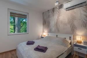 a bedroom with a white bed with a window and a tree at Fácán Fészek Vendégház in Mátraszentimre