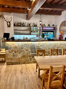 a bar with a stone wall and a table and chairs at Koliba Pod Horů in Dolní Bečva