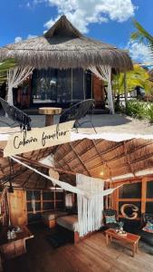 a restaurant with a straw hut with a bench and a table at La playita Sabancuy in Cuba