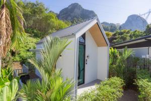 een wit huis met bergen op de achtergrond bij Annrin cafe & Resort in Ban Song Phi Nong