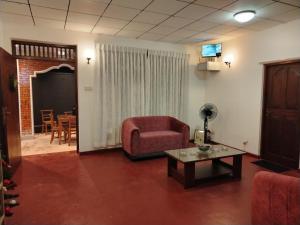 a living room with a couch and a table at Villa Green Garden in Hikkaduwa