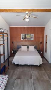 a bedroom with a white bed and a ceiling fan at Tiny Moor Laguna Garzón in José Ignacio