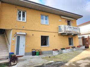 una casa gialla con un balcone e un cartello di BIKE HOUSE "beach" a Seriate