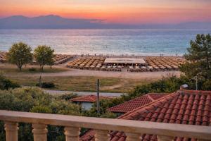 uitzicht op een strand met een groep parasols bij Heraklia villa sea view pool & jacuzzi in Nea Iraklia +99 foto's