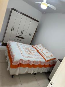 een slaapkamer met een bed en witte kasten bij Conforto a 100 m do mar in Tramandaí +9 foto's