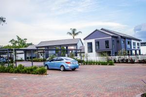 ein blaues Auto, das vor einem Haus geparkt ist in der Unterkunft Luxury 1 Bed Apartment in Sandton