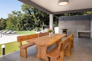 un tavolo da pranzo in legno e panche su un patio di Villa Fabris by Briskva a Kringa Altre 35 foto
