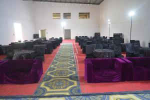 een grote kamer met paarse stoelen en tafels. bij Mahi Baagh Resort in Pāli