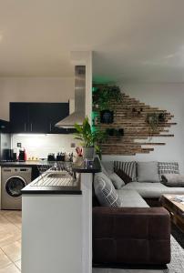 un salon avec un canapé et une cuisine dans l'établissement Chez Louis, à Saint-Flour