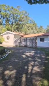 a house with a fence in front of a driveway at Sitio JP in Pindamonhangaba