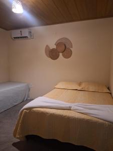 een slaapkamer met een bed en twee borden aan de muur bij Vila Borogodó BG in Barra Grande