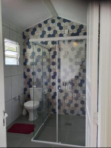 a bathroom with a glass shower with a toilet at Sitio JP in Pindamonhangaba +4 photos