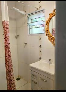 a bathroom with a sink and a mirror at Sitio JP in Pindamonhangaba
