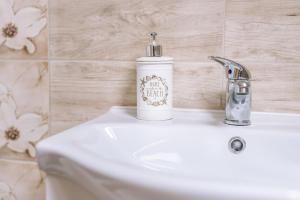 een wastafel met een zeepdispenser bij Leitner Ház in Balatongyörök