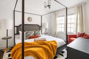 a bedroom with a canopy bed and an orange chair at Golden Gazelle in Atlanta