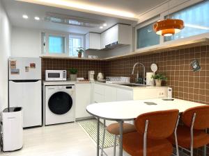 a kitchen with a washing machine and a table at 스테이 무드인 in Seoul