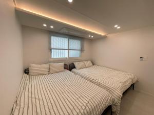 two beds in a room with a window at 스테이 무드인 in Seoul