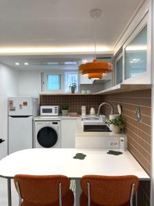 a kitchen with white appliances and a table with chairs at 스테이 무드인 in Seoul +40 photos