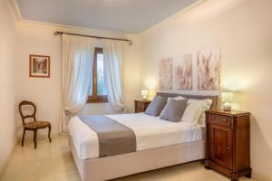 ein Schlafzimmer mit einem großen weißen Bett und einem Stuhl in der Unterkunft Agriturismo Il Cantico di San Francesco in Palazzo + 62 Fotos