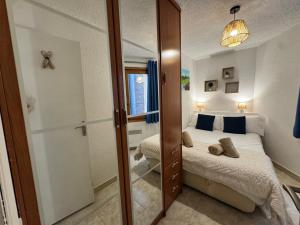 a small bedroom with a bed and a mirror at PROBER_NEVADA II in Pas de la Casa